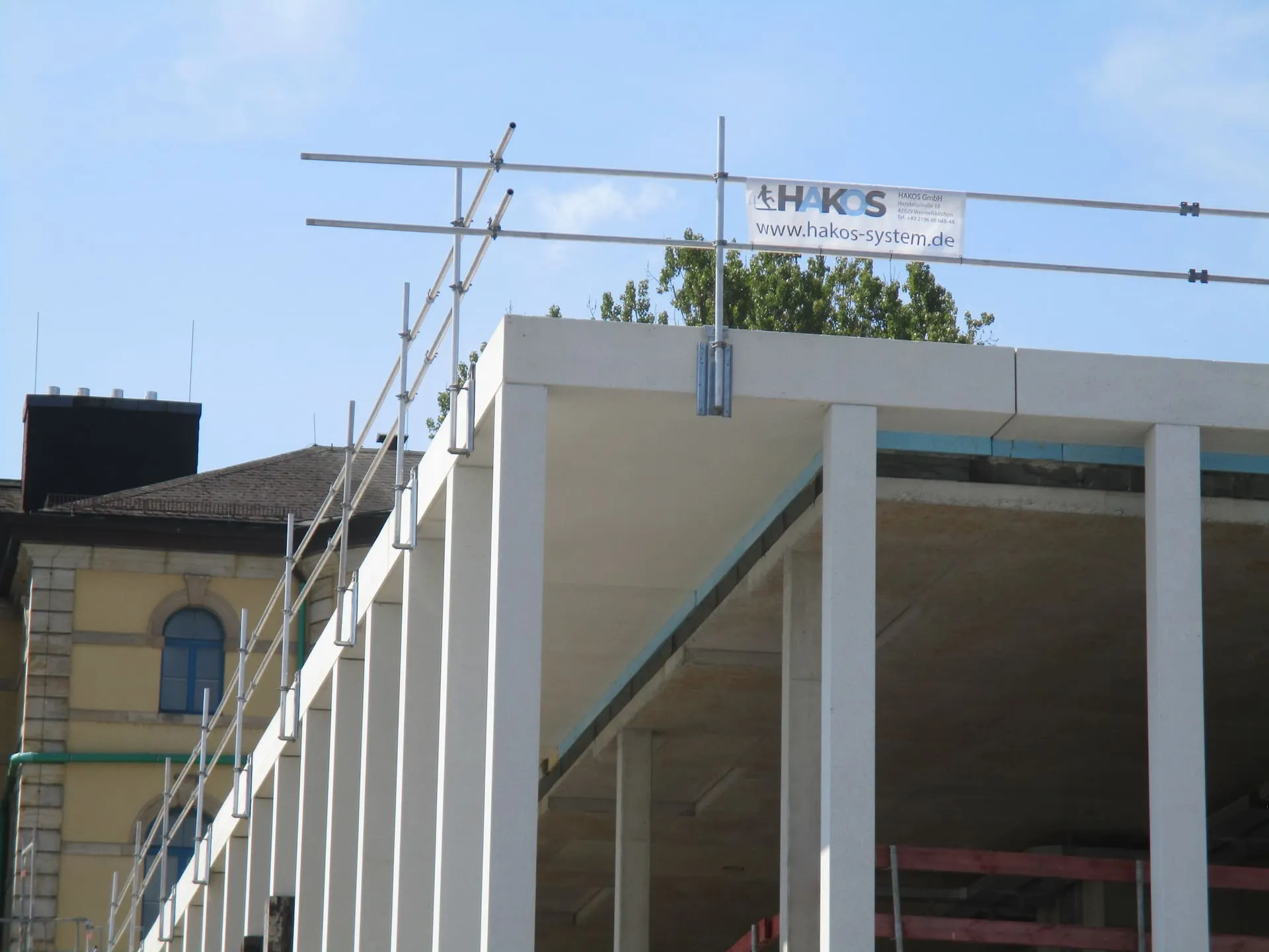 Temporärer HAKOS-Seitenschutz an der Betonattika eines Rohbaus in Bayreuth